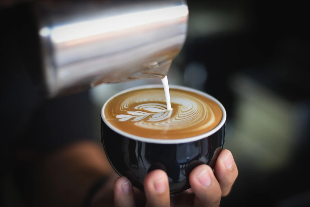 Free pouring milk onto coffee